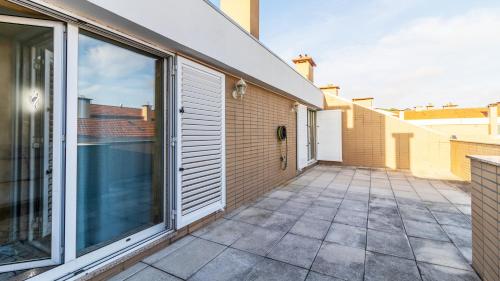 a patio with sliding glass doors on a building at São Felix Seaview Retreat by LovelyStay in São Félix da Marinha