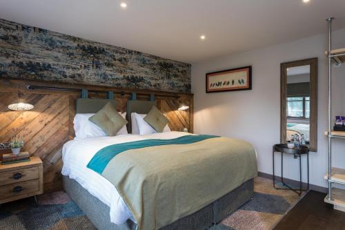 a bedroom with a large bed with a wooden wall at Dartmoor Halfway Inn in Newton Abbot