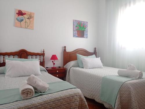dos camas sentadas una al lado de la otra en un dormitorio en Apartamento nuevo en Sierra Sur Sevilla, en Villanueva de San Juan