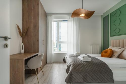 1 dormitorio con cama, escritorio y silla en Symphony Modern Tower Aparthotel, en Gdynia