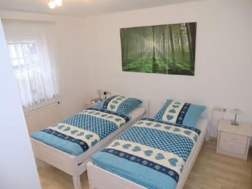 two beds in a room with a picture on the wall at Ferienwohnung Ahorn in Waldshut-Tiengen