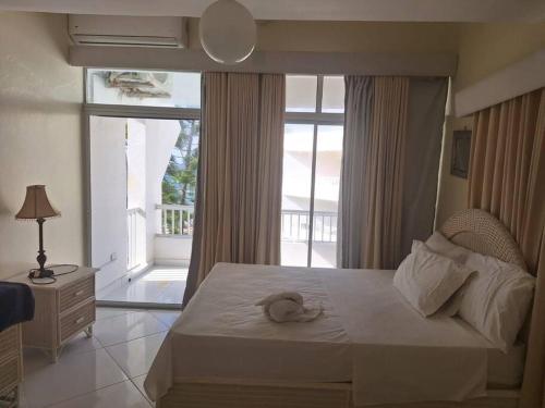 1 dormitorio con cama grande y ventana grande en Appartamento Aruba Juan Dolio fronte mare, en Juan Dolio