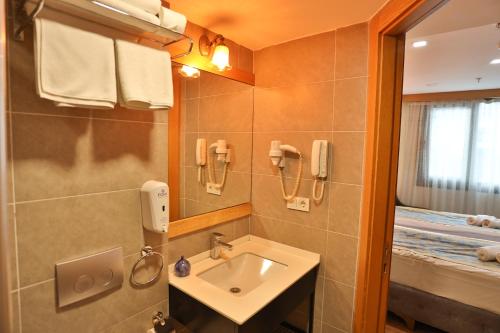 a bathroom with a sink and a mirror at Cumbali Plaza Hotel in Istanbul