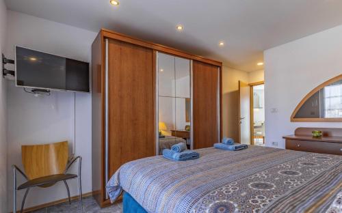 sypialnia z łóżkiem z telewizorem na ścianie w obiekcie Holiday house for 11 persons in Medulin with sea view, terrace, air conditioning, WiFi 3486-4 w Medulinie
