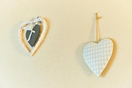 two heart ornaments hanging on a wall at Apartamenty nad Młynówką in Chochołów