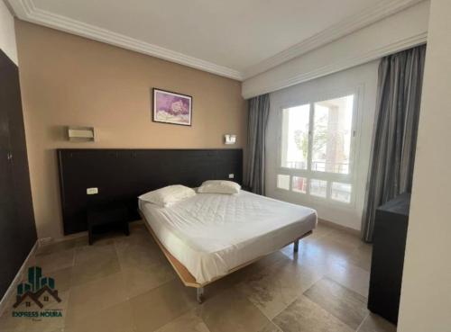 a bedroom with a bed and a large window at App S1 à l'hôtel Andalucia Beach in Bizerte