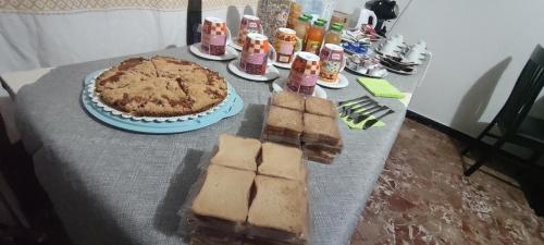 a table with a cake and a pie on it at Sa Burra Guest House in Gadoni