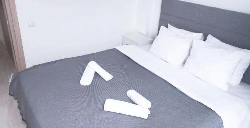 a bed with white sheets and pillows with a letter k on it at Apartment in the center of Athens in Athens