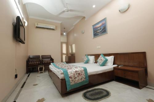 um quarto com uma cama e uma televisão em SUNSHINE RESIDENCY,LAJPAT NAGAR em Nova Deli