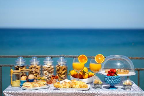 een tafel met een buffet van eten en drinken bij Dolce Vita Rooms and Apartments in Cefalù