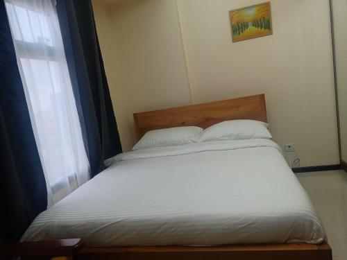 a bed with white sheets and a window in a room at The Radiance Manila Bay Studio 2 in Manila