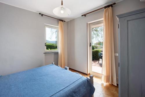 een slaapkamer met een blauw bed en een groot raam bij E6-2 bilocale Borgo della Rovere in San Bartolomeo al Mare