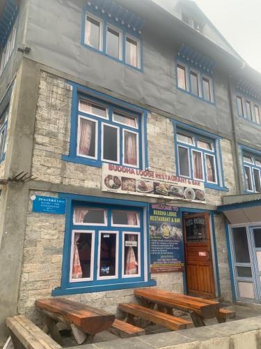 a building with two benches in front of it at Buddha Lodge in Chaunrikharka