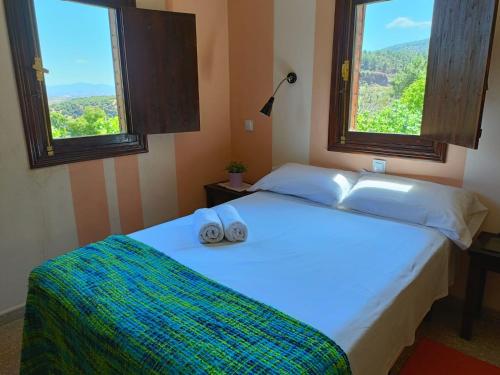 een slaapkamer met een bed met twee handdoeken erop bij Hotel Rural Don Burguillo in El Tiemblo