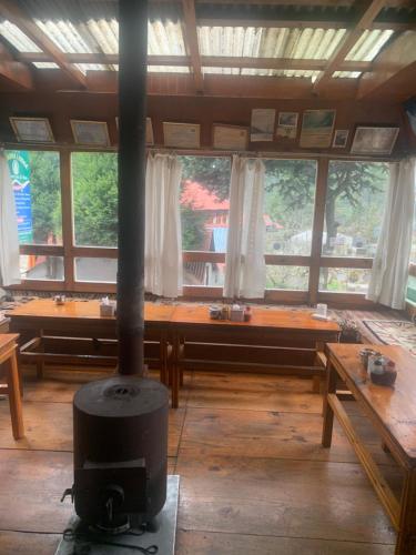 salon z piecem opalanym drewnem w środku w obiekcie Buddha Lodge w mieście Chaunrikharka
