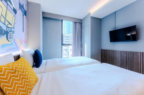 a bedroom with two beds and a flat screen tv at lyf Sukhumvit 8 Bangkok Managed by The Ascott Limited in Bangkok