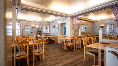 une salle à manger avec des tables et des chaises en bois dans l'établissement Hotel Royal, à Monschau