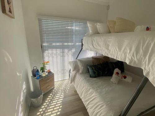 a bedroom with two bunk beds and a window at 32 On Gill Road Self Catering in Cape Town