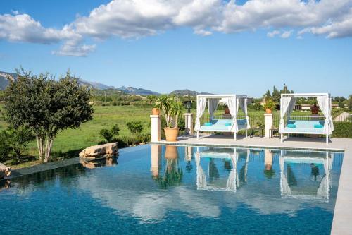 una piscina con 2 sillas azules junto al agua en Cas Metge Matas, en Santa Maria del Camí
