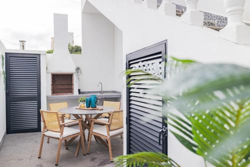 a patio with a table and chairs on a balcony at Casa do Helio - Beach House in Ponta Delgada