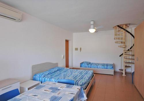 a bedroom with two beds and a spiral staircase at Orizzonti in Marina di Campo