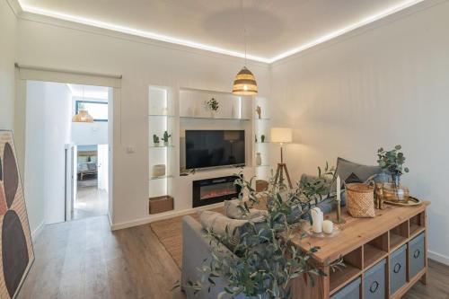 a living room with a couch and a tv at Casa do Helio - Beach House in Ponta Delgada