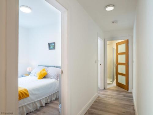 ein weißes Schlafzimmer mit einem Bett und einem Flur in der Unterkunft Kings apartment 2 391 in Gowlaun