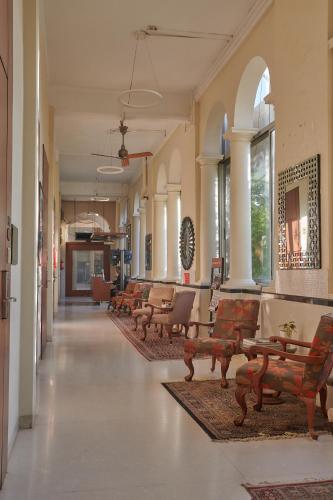 a hallway with chairs and tables in a building at Elphinstone Hotel in Mumbai