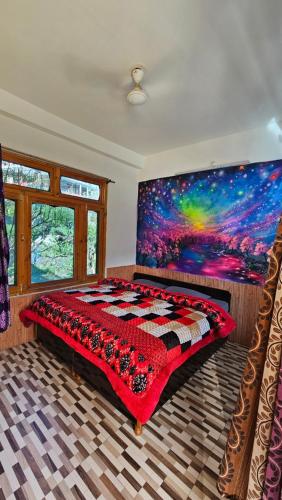 1 dormitorio con 1 cama con una pintura en la pared en Formosa Hostel & Cafe en Kasol