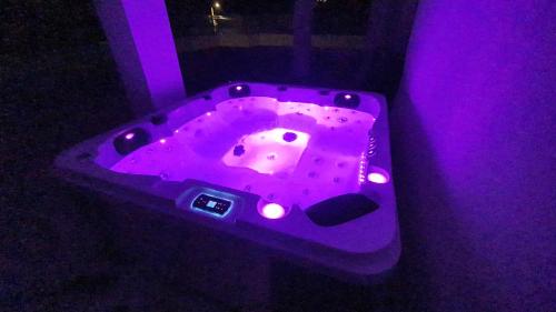 a purple bath tub with lights in a room at Ferienwohnung Adriaperle Villa Casper mit Whirlpool in Palit