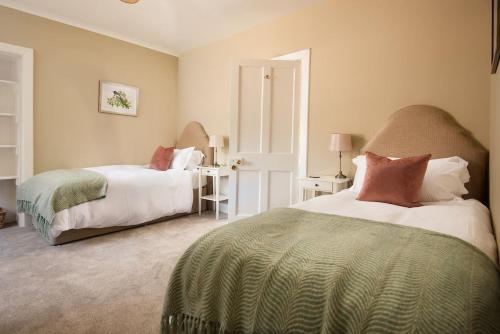 ein Schlafzimmer mit zwei Betten und zwei Tischen mit Lampen in der Unterkunft Laurel Cottage in Cockburnspath