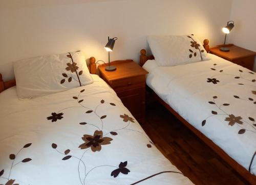 a bedroom with two beds with flowers on the sheets at M038 Accony, Louisburgh in Louisburgh