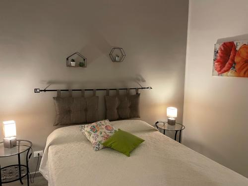 a bedroom with a bed with two tables and two lamps at "Il Gelso" in Villa G reco in Tindari