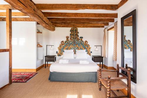 a bedroom with a large white bed with a wooden headboard at MAISON BASQUE D'EXCEPTION - SARE in Sare