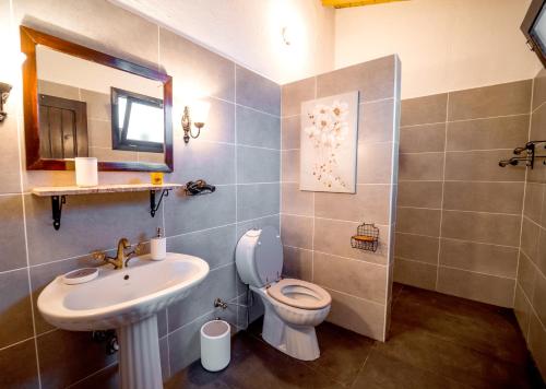 een badkamer met een wastafel, een toilet en een spiegel bij Chef's Otelier in Kuşadası