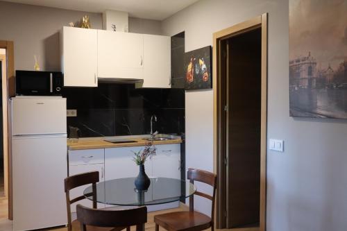 a small kitchen with a table and a refrigerator at Casa-Museo Genia Trigo in Sober
