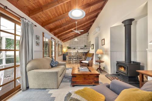 a living room with a couch and a stove at Jamieson Cottages - Cottage Three - Sleeps 4 in Howqua