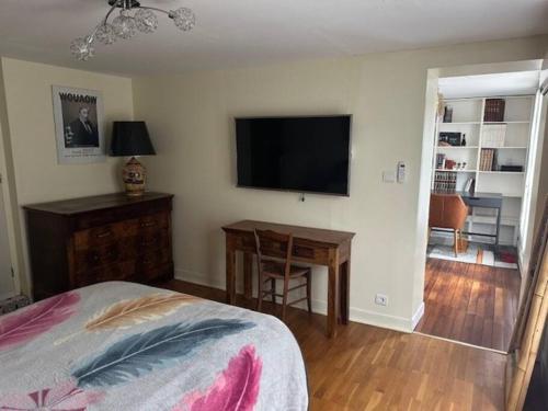Schlafzimmer mit einem Bett, einem Tisch und einem TV in der Unterkunft Appartement dans résidence calme dans les Monts du Lyonnais in Soucieu-en-Jarrest