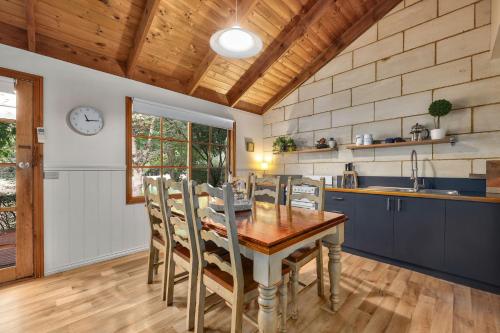 a kitchen with a wooden table and chairs in a room at Jamieson Cottages - Cottage Three - Sleeps 4 in Howqua