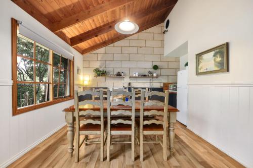 a kitchen with a wooden table and chairs at Jamieson Cottages - Cottage Three - Sleeps 4 in Howqua