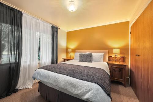 a bedroom with a large bed and a window at Jamieson Cottages - Cottage Three - Sleeps 4 in Howqua