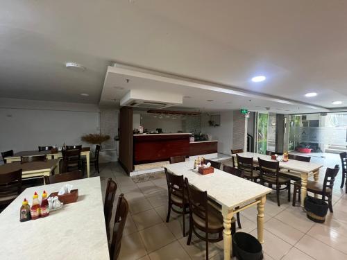 a restaurant with tables and chairs and a kitchen at A25 Hotel - 29 Bùi Thị Xuân in Ho Chi Minh City