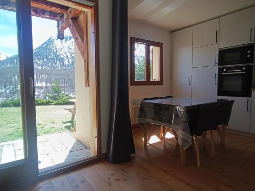 - une cuisine avec une table et une vue sur la montagne dans l'établissement Studio rénové plein sud, terrasse-jardinet, 4 pers, proche pistes et commerces, stationnement privé. - FR-1-445-204, à Montgenèvre