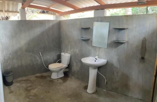 uma casa de banho com um WC e um lavatório em Upali Beach Surf Resort & Café em Arugam Bay