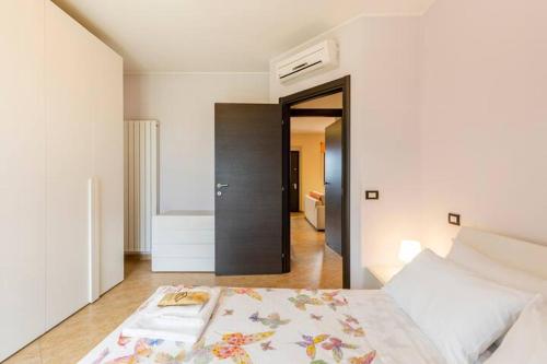 Dormitorio blanco con cama y pasillo en Vacancuore, a casa di Giada, en Bastia Umbra