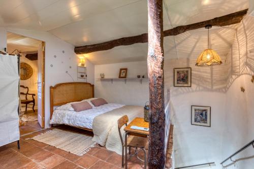 a bedroom with a bed and a table at Maison de village in La Tour-sur-Orb