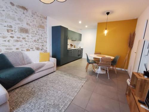 uma sala de estar com um sofá e uma mesa em Appartement cosy aux Beaux-arts em Montpellier