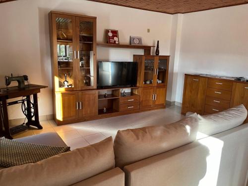 Il comprend un salon doté d'un canapé et d'une télévision à écran plat. dans l'établissement Casa do Castelo- Serra da estrela, à Covilhã