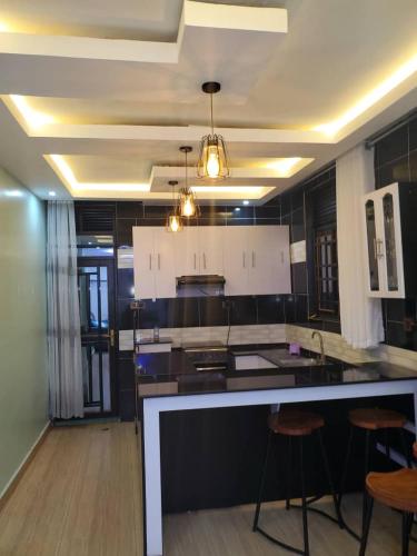 cocina grande con encimera y taburetes en IP House en Kigali