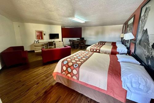 a hotel room with two beds and a living room at Super 8 by Wyndham Athens TX in Athens